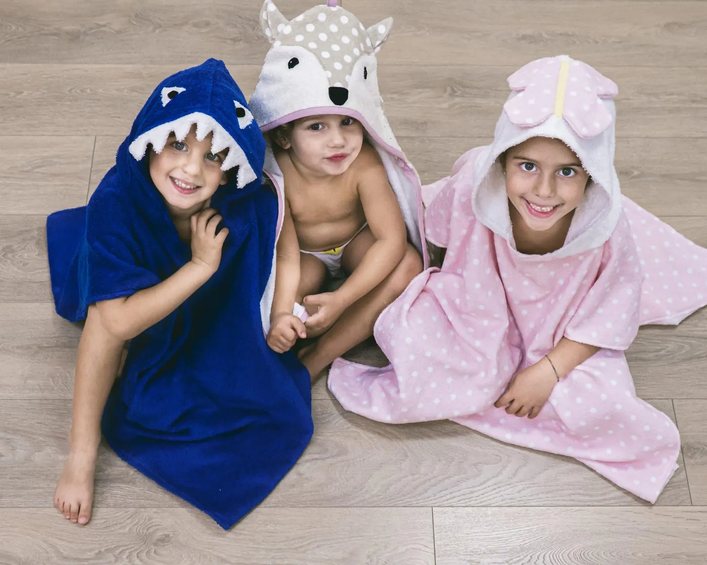 Tre bambini con gli accappatoi Petit Lapin a forma di animale